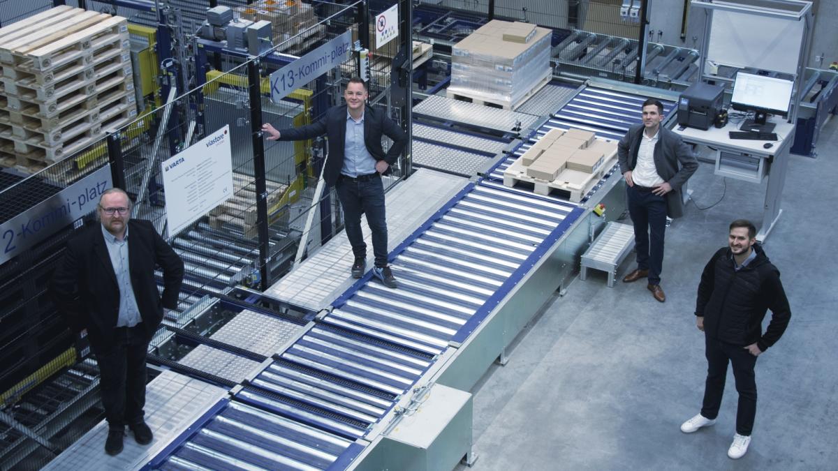 Four people in the viastore high-bay warehouse at VARTA, project managers at viastore, prismat, VARTA 