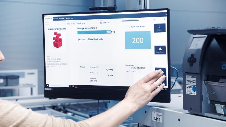Lagermitarbeiterin bedient Bildschirm mit Warehouse Management System viadat von viastore