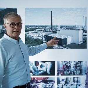Mitarbeiter der Firma JUNG vor dem Bild des Logistikzentrums