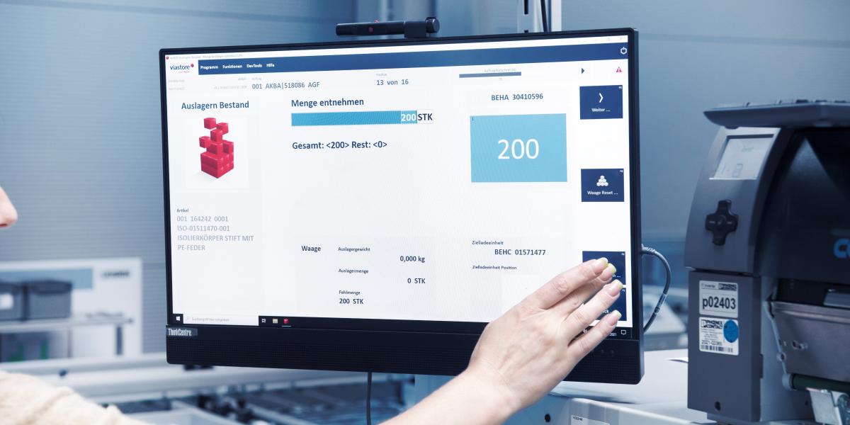 Lagermitarbeiterin bedient Bildschirm mit Warehouse Management System viadat von viastore